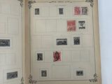 an open book with stamps on it sitting on a table