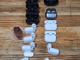 a wooden table topped with white and black airpods