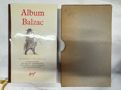 un vieux livre sur lequel figure l'image d'un homme coiffé d'un haut-de-forme, assis sur une table