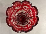 a red and white glass bowl on a white surface