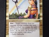 a close up of a card with a picture of a woman holding a scythe