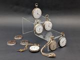 many different types of pocket watches displayed on the table