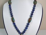 un gros plan d'un collier sur un mannequin, orné de perles bleues