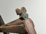 a close up of a wooden chair with a green stone on the seat