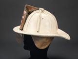 an old white fireman ' s hat with a sticker on it