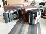 three old cameras sitting on a table next to each other