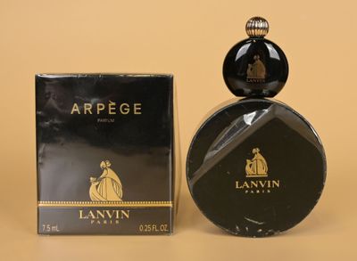 a close up of a bottle of perfume next to a box