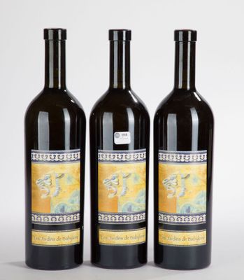 trois bouteilles de vin posées l'une à côté de l'autre sur une table