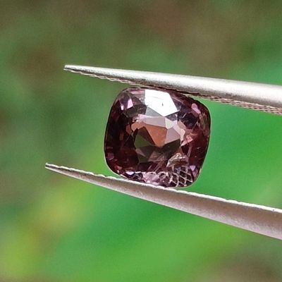 someone is holding a pair of pliers with a pink diamond in it