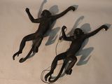two monkey statues on a table with wires attached to them