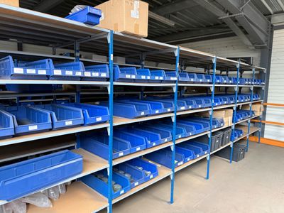 shelves with blue bins and boxes in a storage room