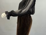 an image of a mannequin wearing a black dress with sheer sleeves