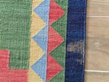 a close up of a colorful rug on a wooden floor