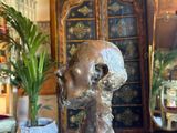 a statue of a skull on a pedestal in a living room