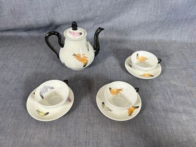 un service à thé et à café en porcelaine de quatre pièces, posé sur une nappe bleue