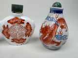 three chinese porcelain snuff bottles with dragon designs on them