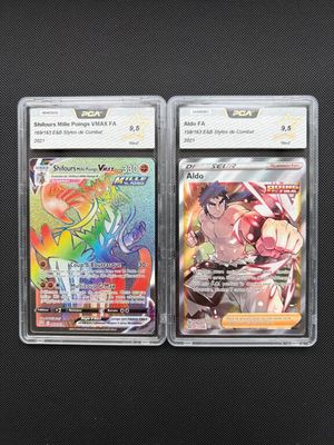 two pokemon trading cards in plastic cases on a black surface