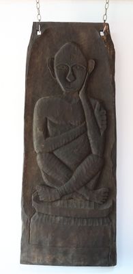 une sculpture représentant un homme tenant un bébé contre un mur