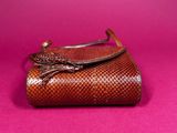 a brown purse sitting on top of a pink surface