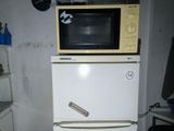 a microwave sitting on top of a refrigerator in a kitchen