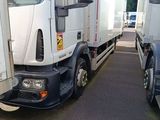 two white trucks parked next to each other in a parking lot