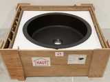 a black sink in a wooden box on the floor