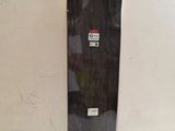 un skateboard noir posé sur une surface blanche