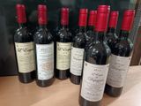 six bouteilles de vin rouge sont alignées sur une table
