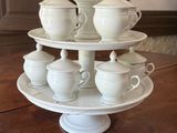 a three tiered plate with cups and saucers on it