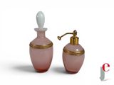 pair of pink glass perfume bottles with gold trim on a white background