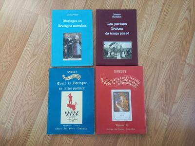 quatre livres posés sur un parquet, avec un parquet en arrière-plan