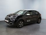 Une Citroën noire est garée dans une grande pièce