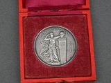 an image of a silver medal in a red box on a table