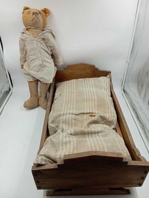 un ours en peluche posé à côté d'un lit