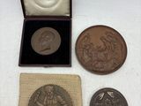 trois médailles de bronze dans une boîte avec un sac en tissu