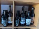 de nombreuses bouteilles de bière posées sur une étagère dans une pièce