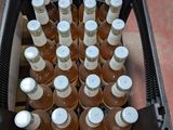 de nombreuses bouteilles de bière dans une caisse noire posée par terre