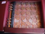 a red case with a bunch of coins inside of it