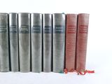 several books are lined up in a row on a white surface