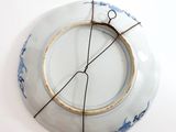 a blue and white plate with a wire around it