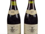 deux bouteilles de vin posées l'une à côté de l'autre sur une surface blanche