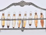 five glass bottles with liquid in them on a metal rack
