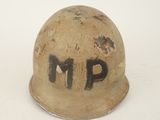 un vieux casque sur lequel est peint « m p »