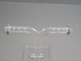 une paire de boucles d'oreilles posée sur un présentoir transparent