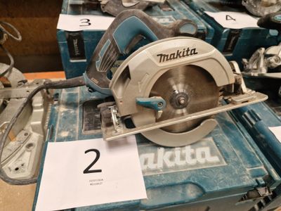 deux scies circulaires posées sur une table sur laquelle est inscrit un numéro