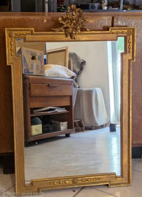 un miroir posé sur le sol devant une commode