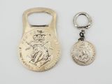 a close up of a bottle opener and a coin on a white surface