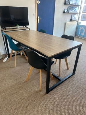 tables and chairs in a room with a flat screen tv on the wall