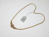 gros plan sur un collier en or portant une étiquette