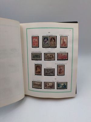 an open book with a bunch of stamps on it sitting on a table